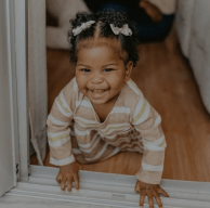 Bebê de 9 meses em quarto sorrindo