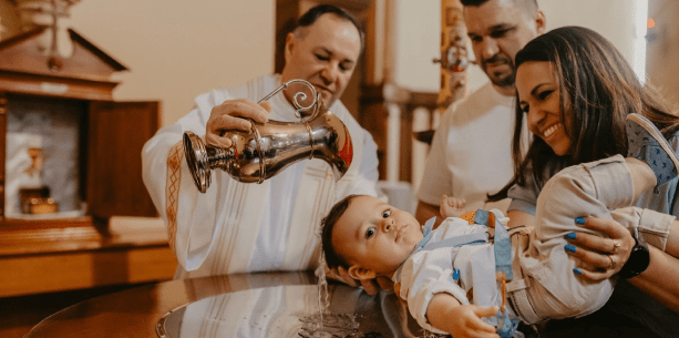 Bebê olhando para a câmera enquanto é batizado